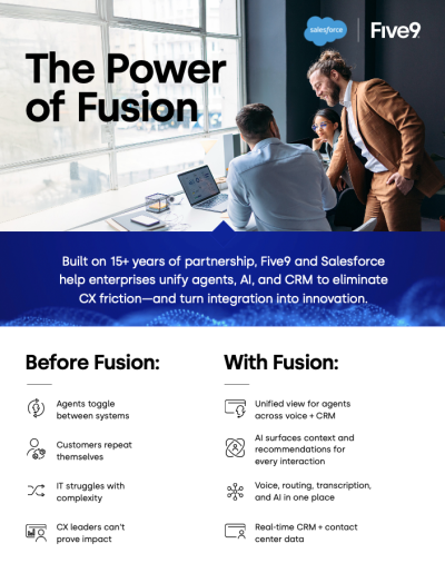 A group of business professionals discussing at a table, with a laptop open, surrounded by notes.