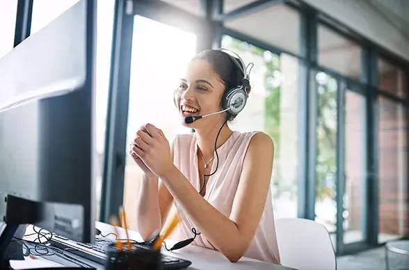 Woman customer support representative smiling at her desk smiling on a call