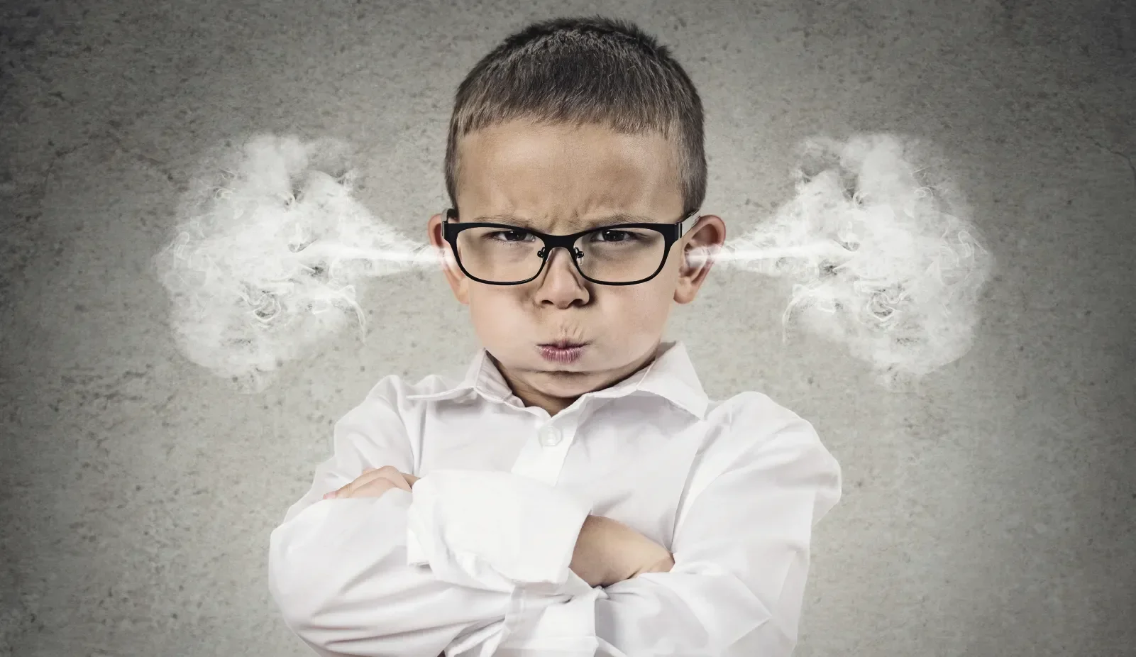 A child dressed in business wear, wearing glasses. His arms are folded and there is steam coming out of his ears