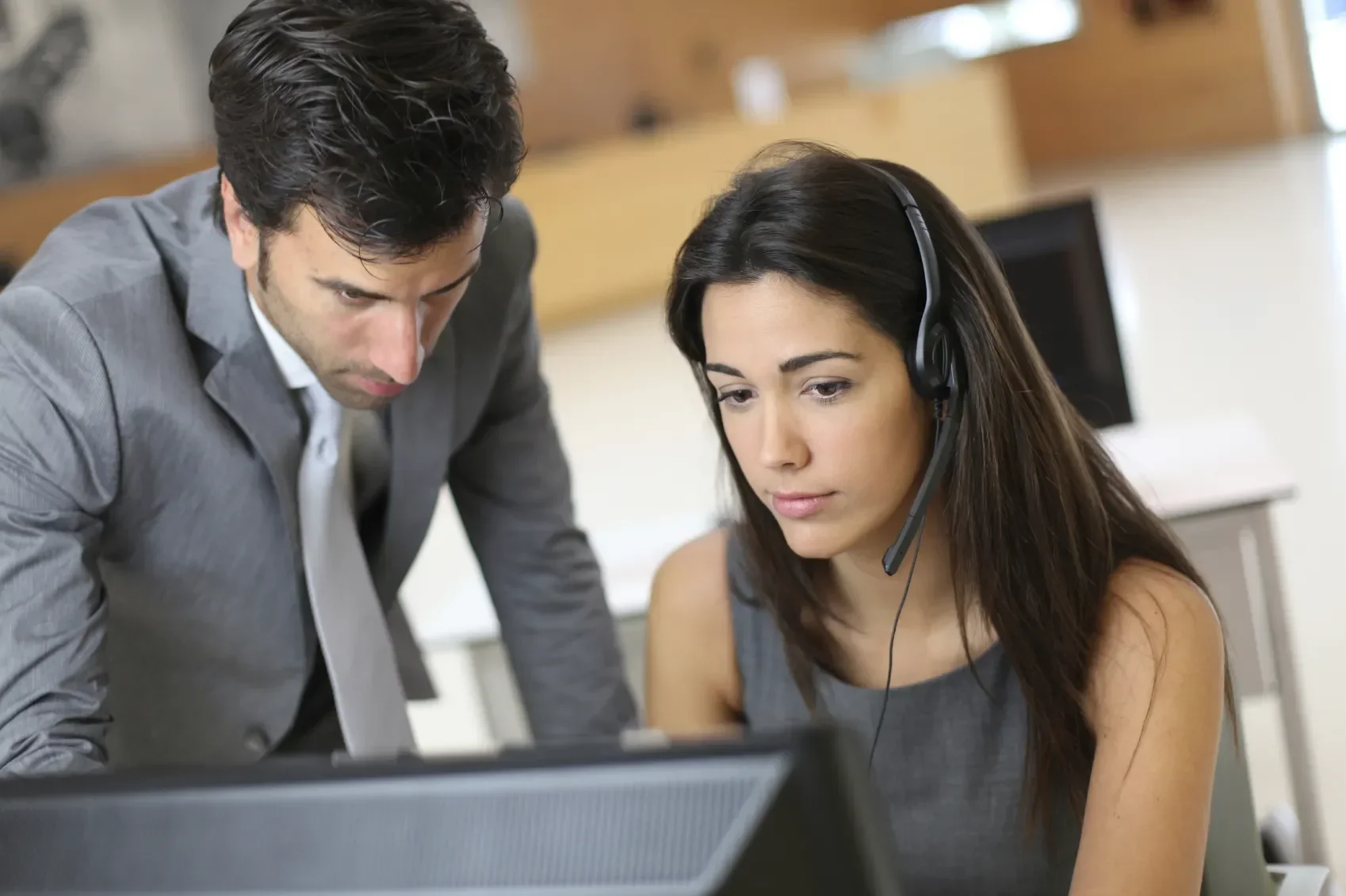 A man and a woman looking at a computer
