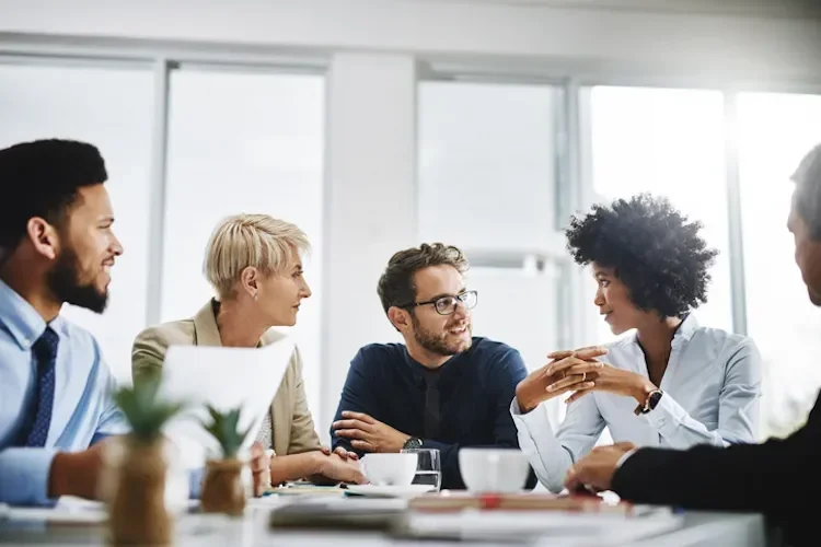 A group of people sat around a table, talking