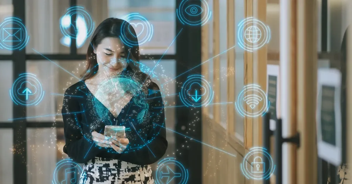 Woman standing with phone surrounded by blue digital icons