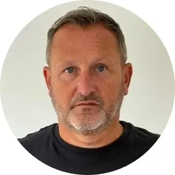 Middle-aged man with short gray hair and beard, looking directly at the camera.