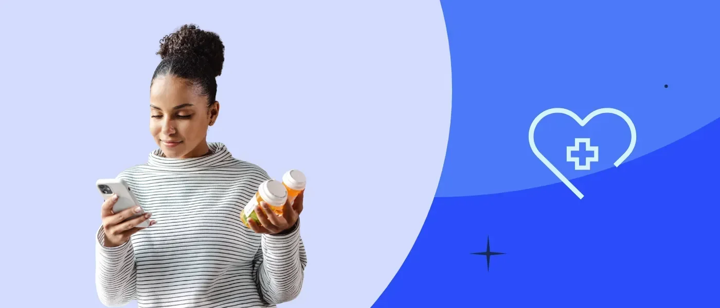 Woman in a gray sweater holding a phone and containers of medication against a blue background.