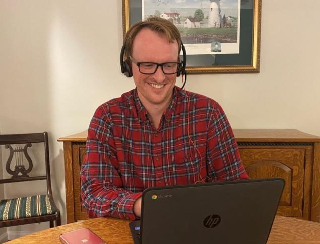 man in plaid shirt at laptop