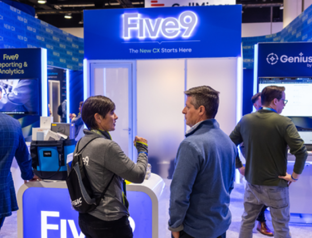Crowd interacting at a trade show booth with "Five9" signage in a vibrant setting.