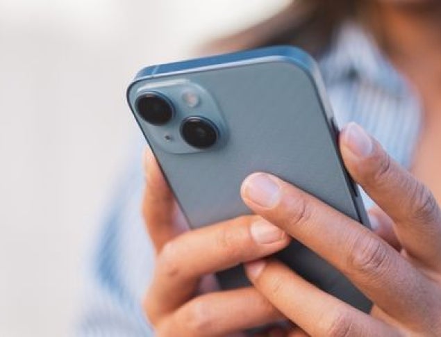 A person holding a smartphone with a gray case, focused on the screen.
